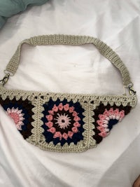 a crocheted fanny bag on a bed