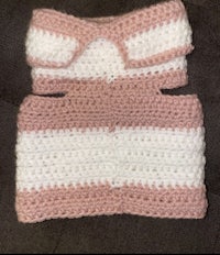 a pink and white crocheted dog sweater