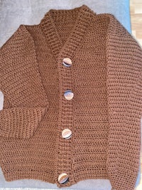 a brown knitted cardigan with buttons on a couch