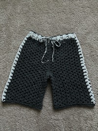 a black and white crocheted shorts on a carpet