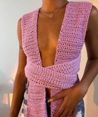 a woman wearing a pink crocheted vest