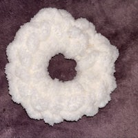 a white crocheted ring on a purple surface