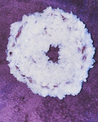 a white donut on a purple surface